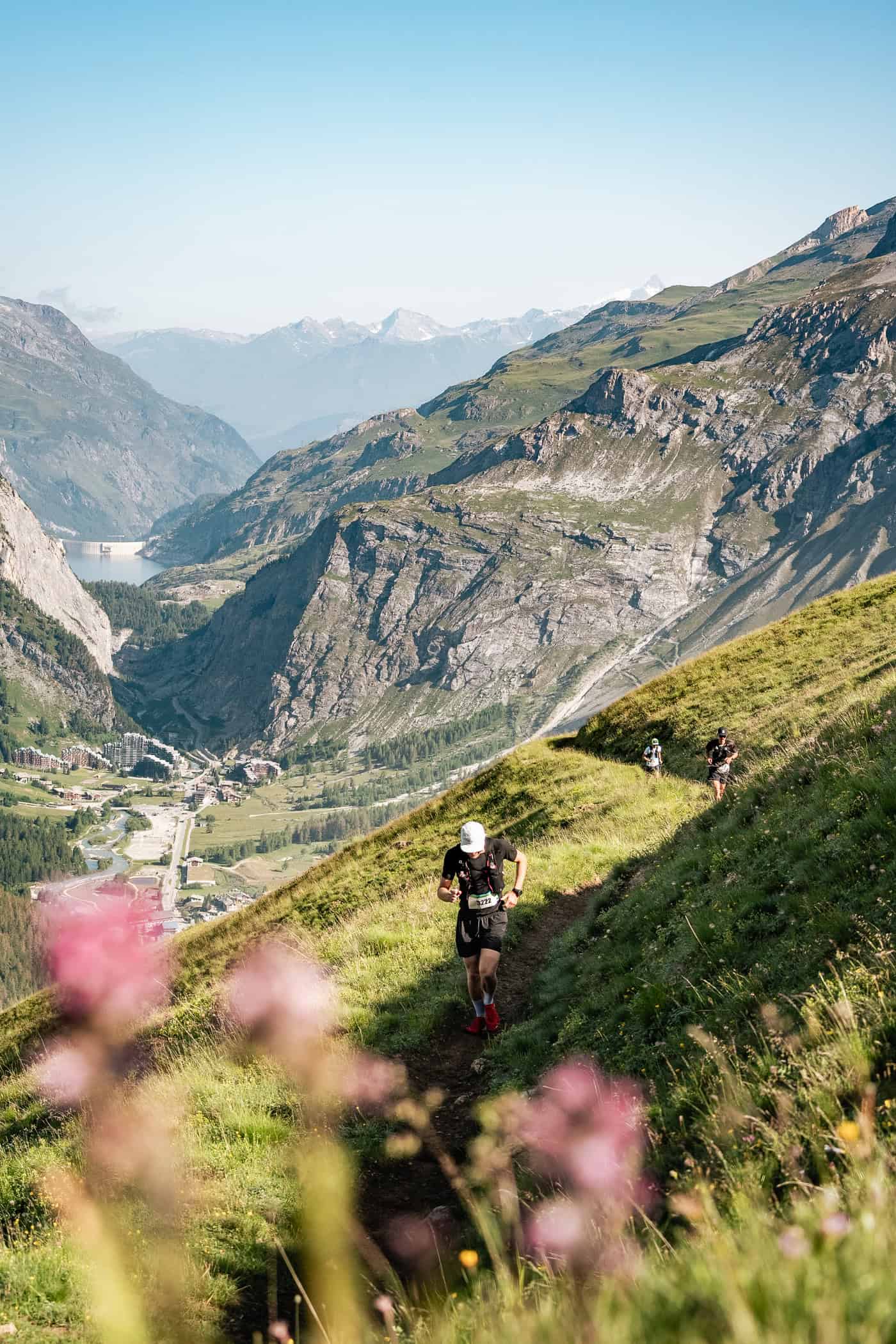 Des coureurs sur un sentier de randonnée avec Val d'Isère en fond